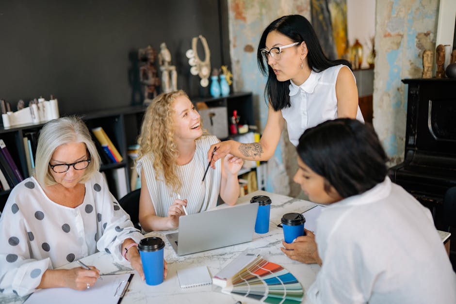 A diverse group of women collaborating in a modern office setting, discussing ideas and working together.